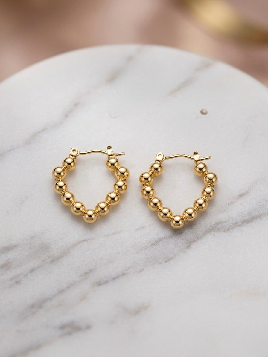 Elegant gold beaded heart hoop earrings.