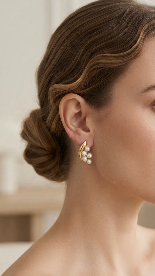 Elegant gold crescent pearl stud earrings.