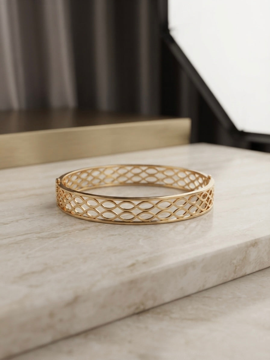 Modern interlocking gold geometric bangle.