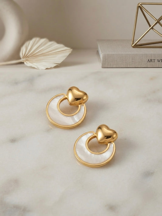 Gold heart and mother-of-pearl earrings.