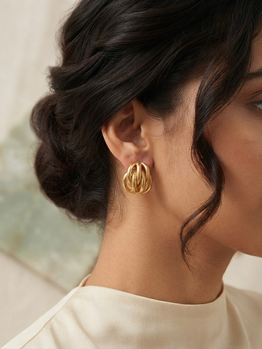 Interwoven golden cage statement earrings.