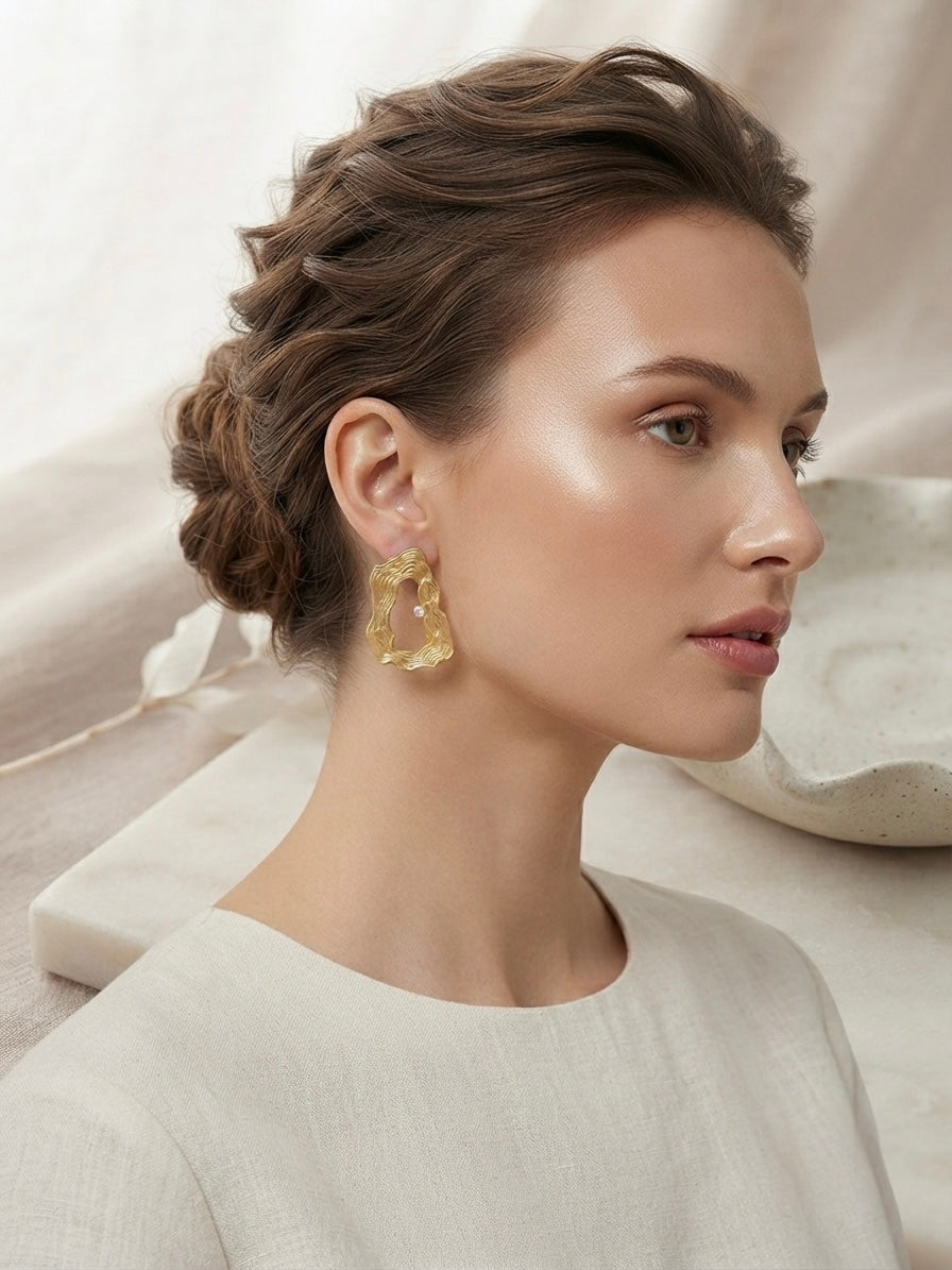 Textured wavy gold crystal hoop earrings.