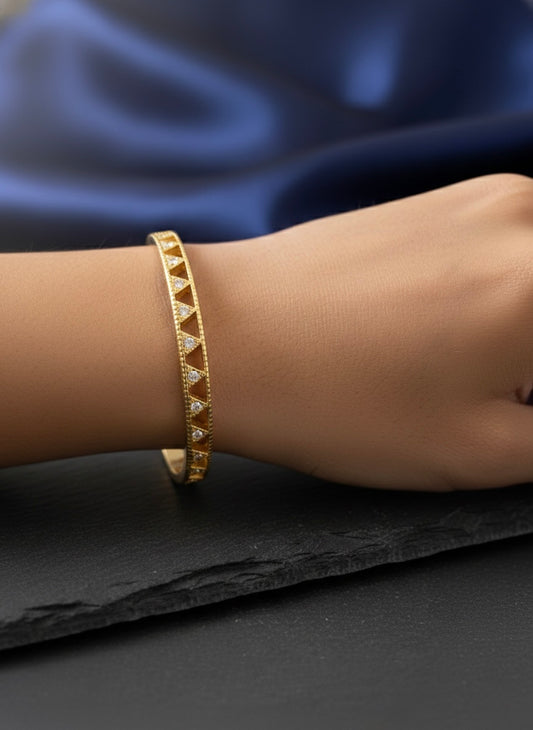 Elegant gold bangle with geometric sparkle
