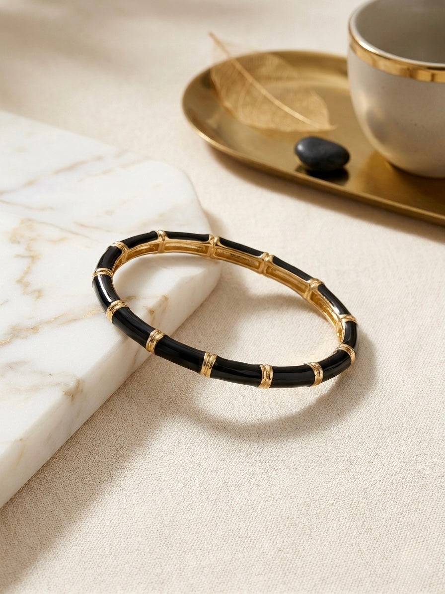 Gold bamboo-style black enamel bracelet .