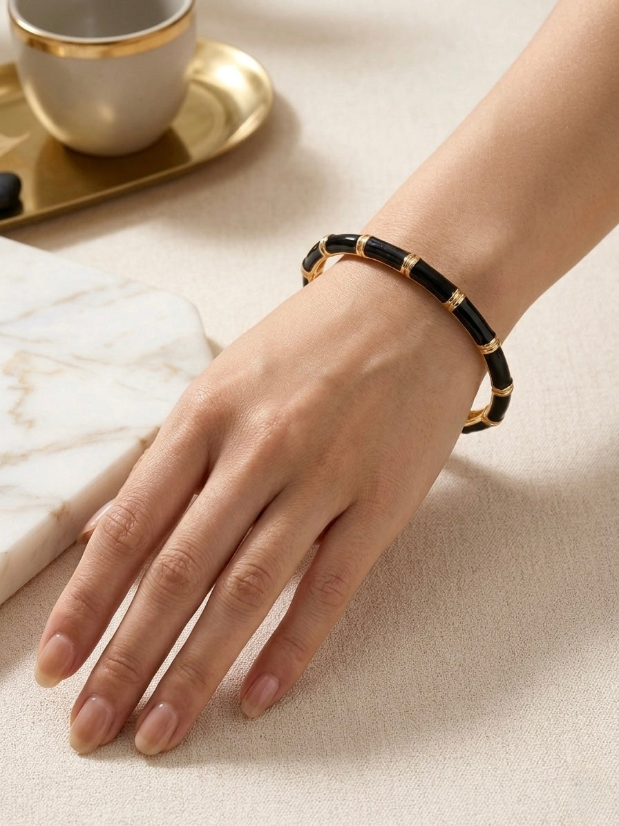 Gold bamboo-style black enamel bracelet .