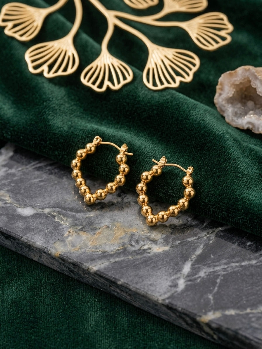Elegant gold beaded heart hoop earrings.