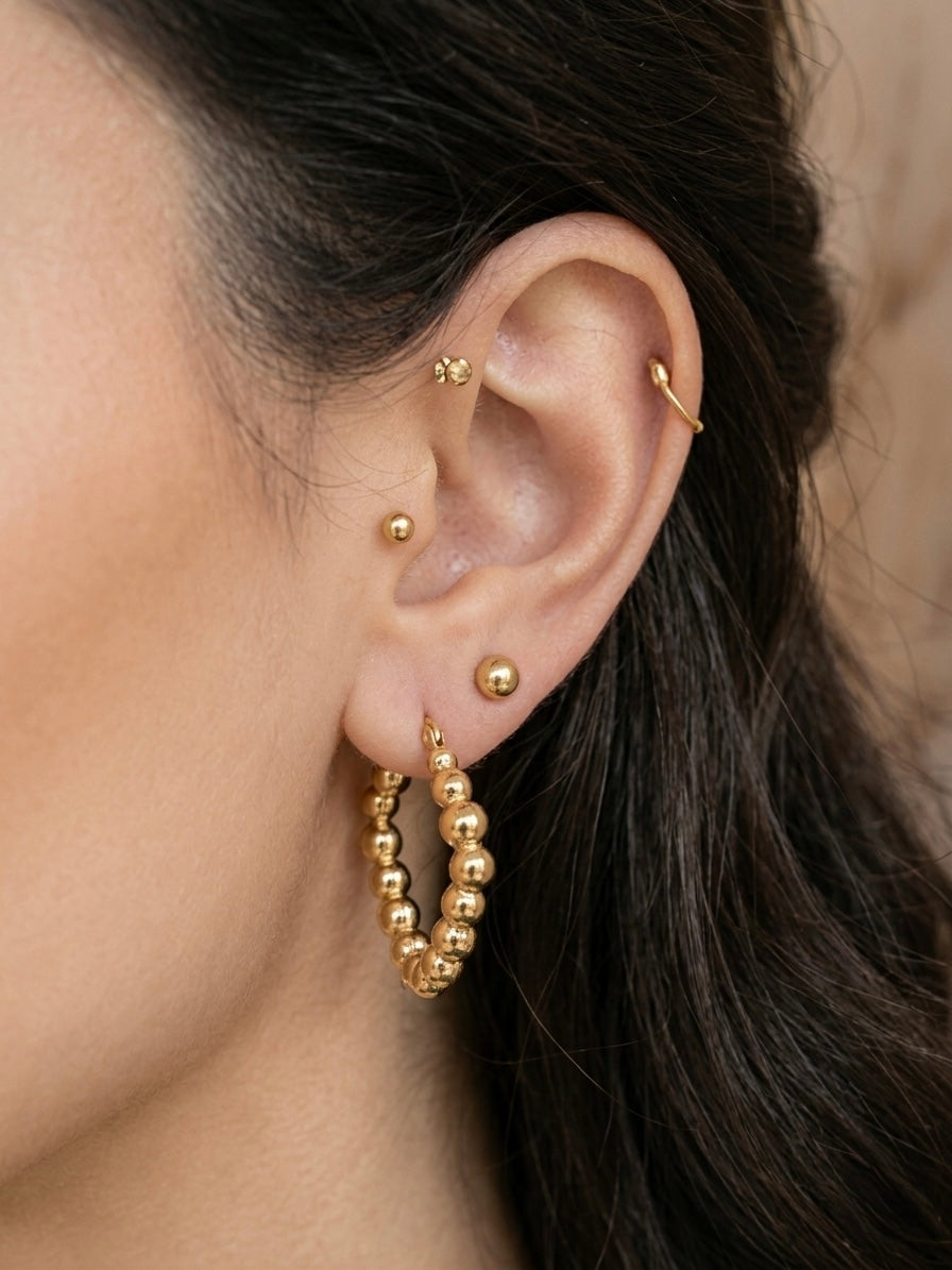 Elegant gold beaded heart hoop earrings.