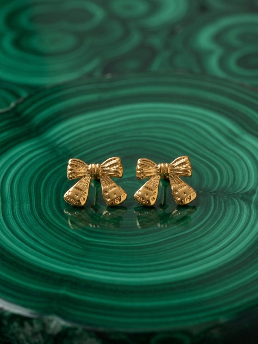 Vintage-style detailed gold bow studs.