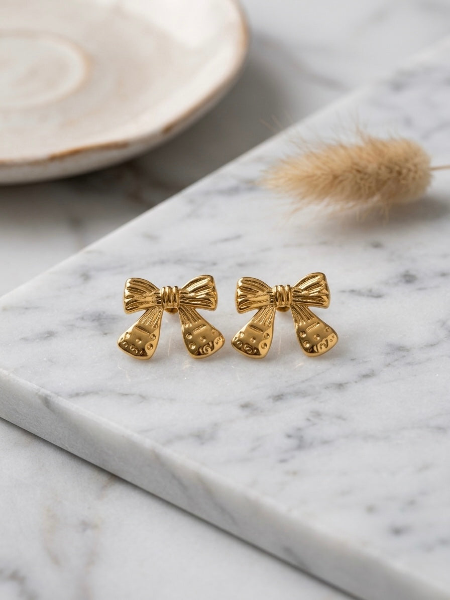 Vintage-style detailed gold bow studs.
