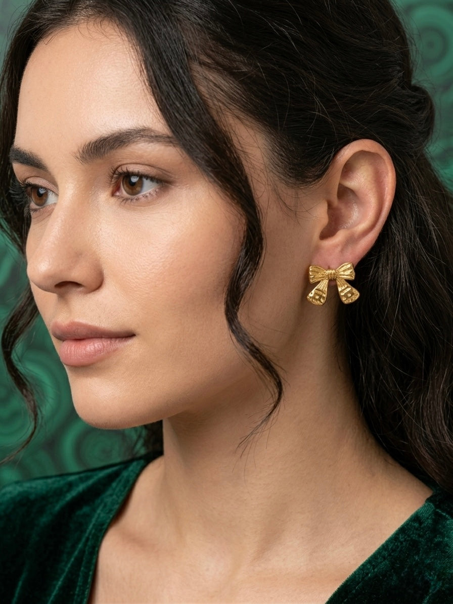 Vintage-style detailed gold bow studs.