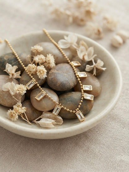 Radiant gold baguette charm necklace.