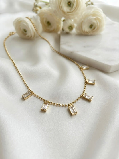 Radiant gold baguette charm necklace.