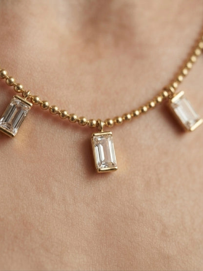 Radiant gold baguette charm necklace.