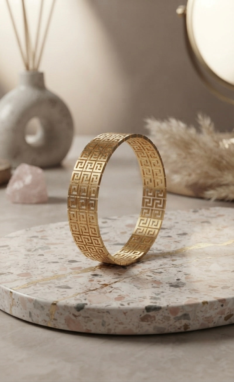 Elegant gold Greek-pattern Kada bracelet.
