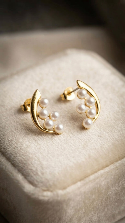 Elegant gold crescent pearl stud earrings.
