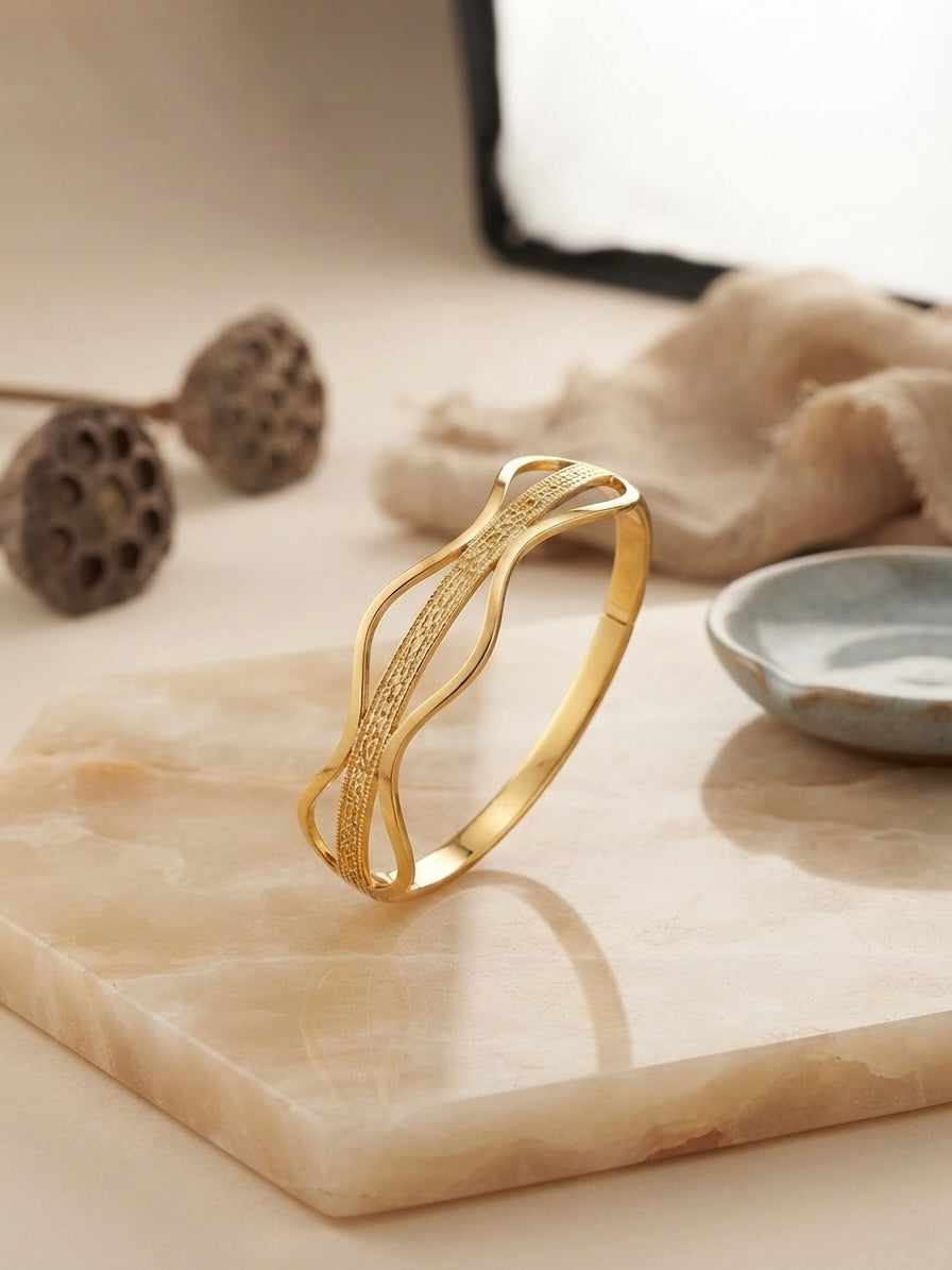 Elegant wavy gold statement bracelet.