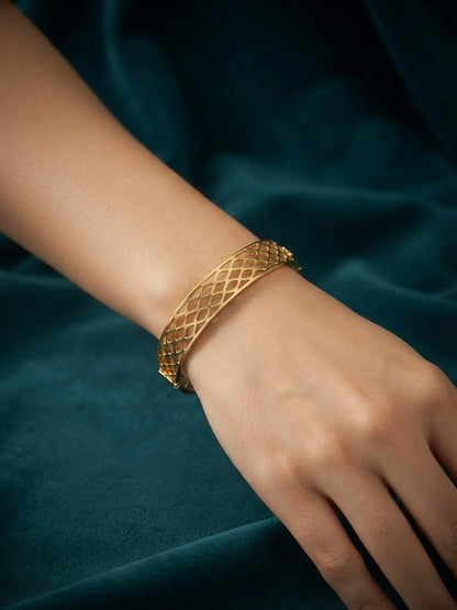 Modern interlocking gold geometric bangle.