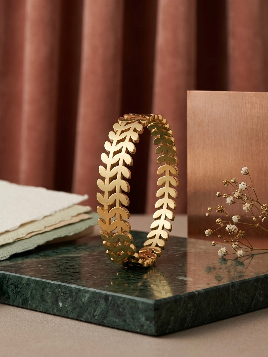 Nature-inspired polished gold leaf cuff.