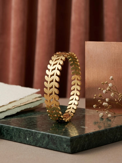 Nature-inspired polished gold leaf cuff.