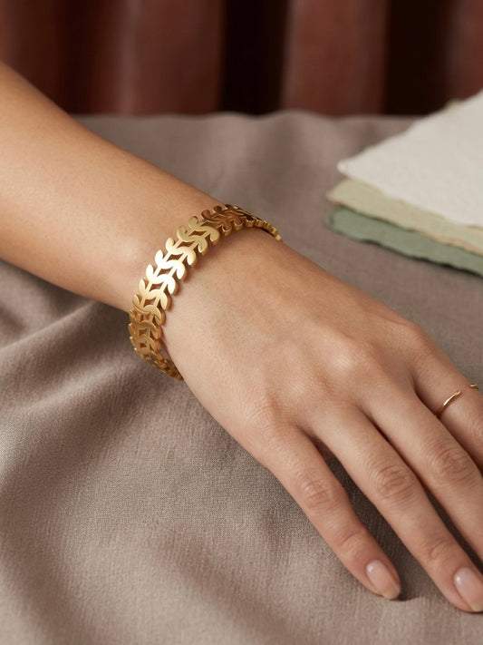 Nature-inspired polished gold leaf cuff.