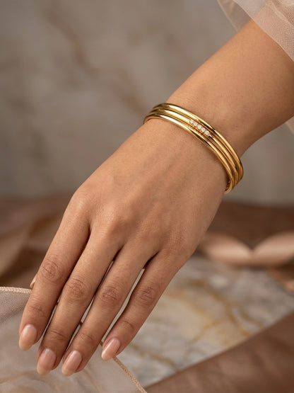 Sophisticated triple-ring gold statement bracelet.