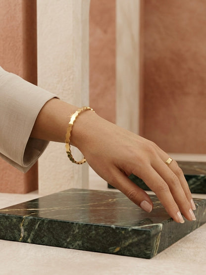 Modern wavy silhouette gold bracelet.