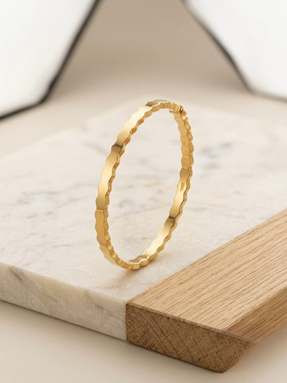 Modern wavy silhouette gold bracelet.