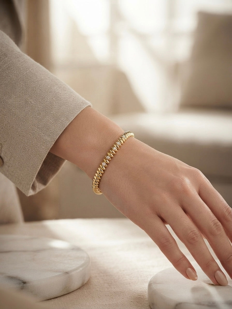 Elegant ridged stone-accented gold bangle.