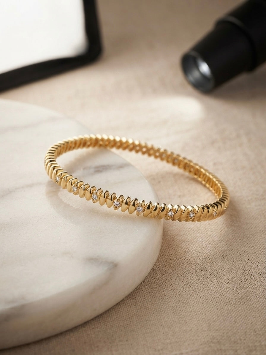 Elegant ridged stone-accented gold bangle.
