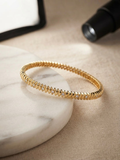 Elegant ridged stone-accented gold bangle.