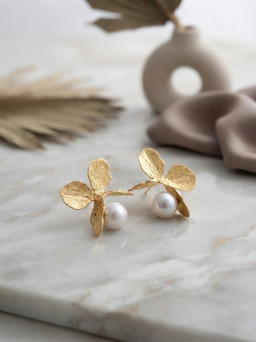 Golden butterfly pearl drop earrings.