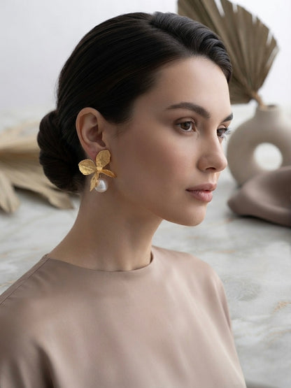 Golden butterfly pearl drop earrings.