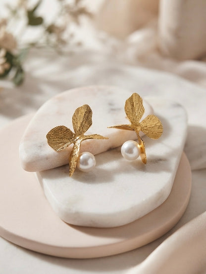 Golden butterfly pearl drop earrings.