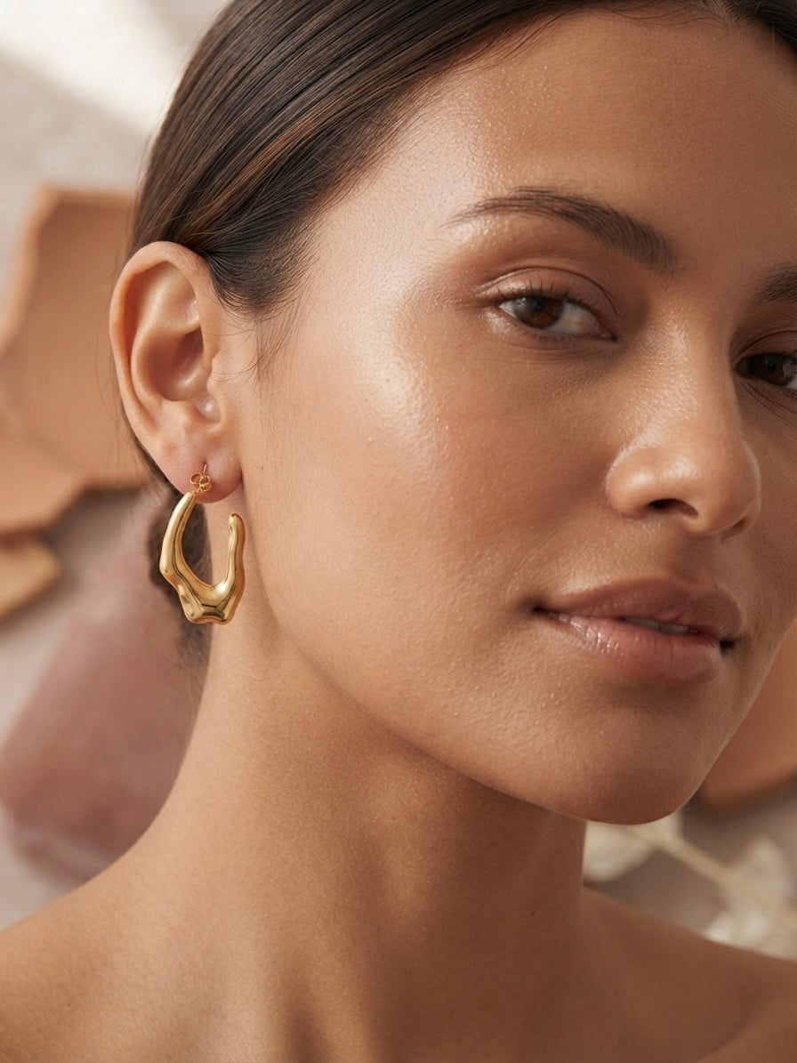 Sculptural molten gold texture statement hoops.