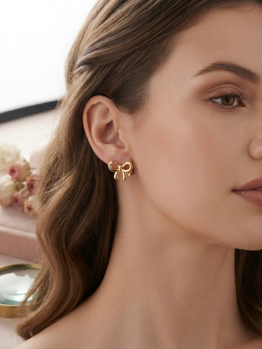 Charming polished gold bow stud earrings.