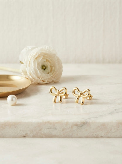 Charming polished gold bow stud earrings.