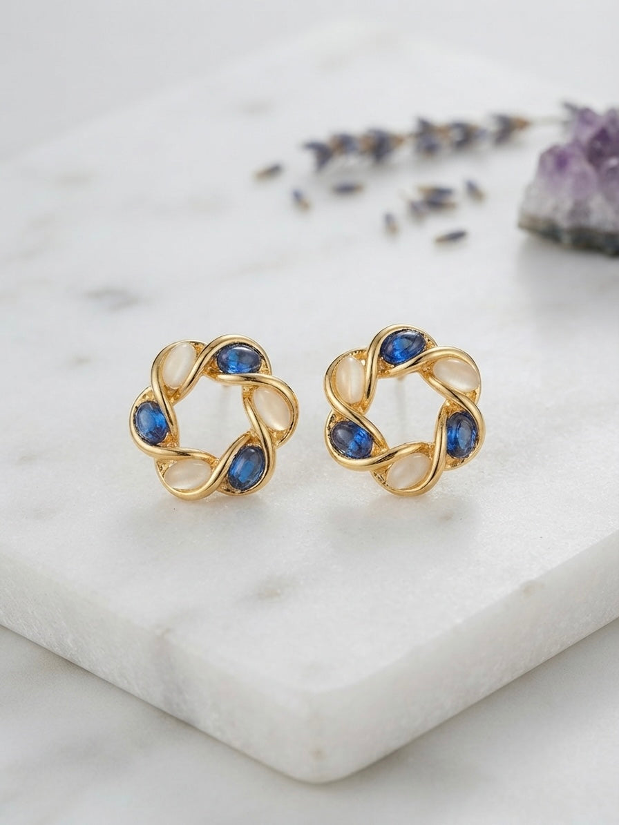 Intertwined gold moonstone and sapphire earrings.