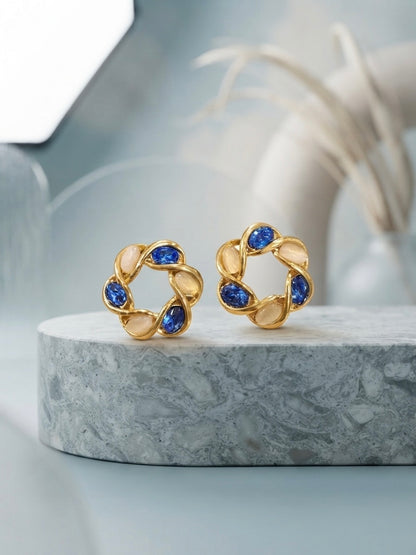 Intertwined gold moonstone and sapphire earrings.