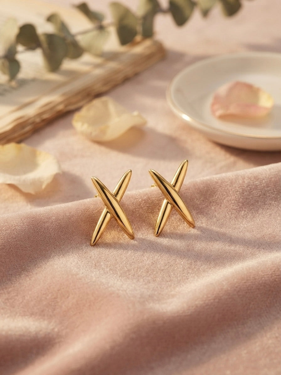 Modern geometric cross gold stud earrings.