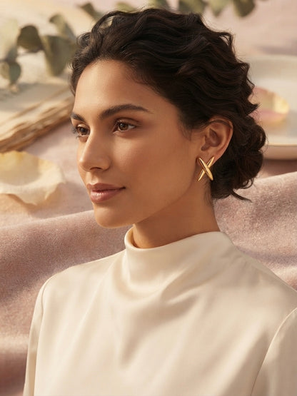 Modern geometric cross gold stud earrings.