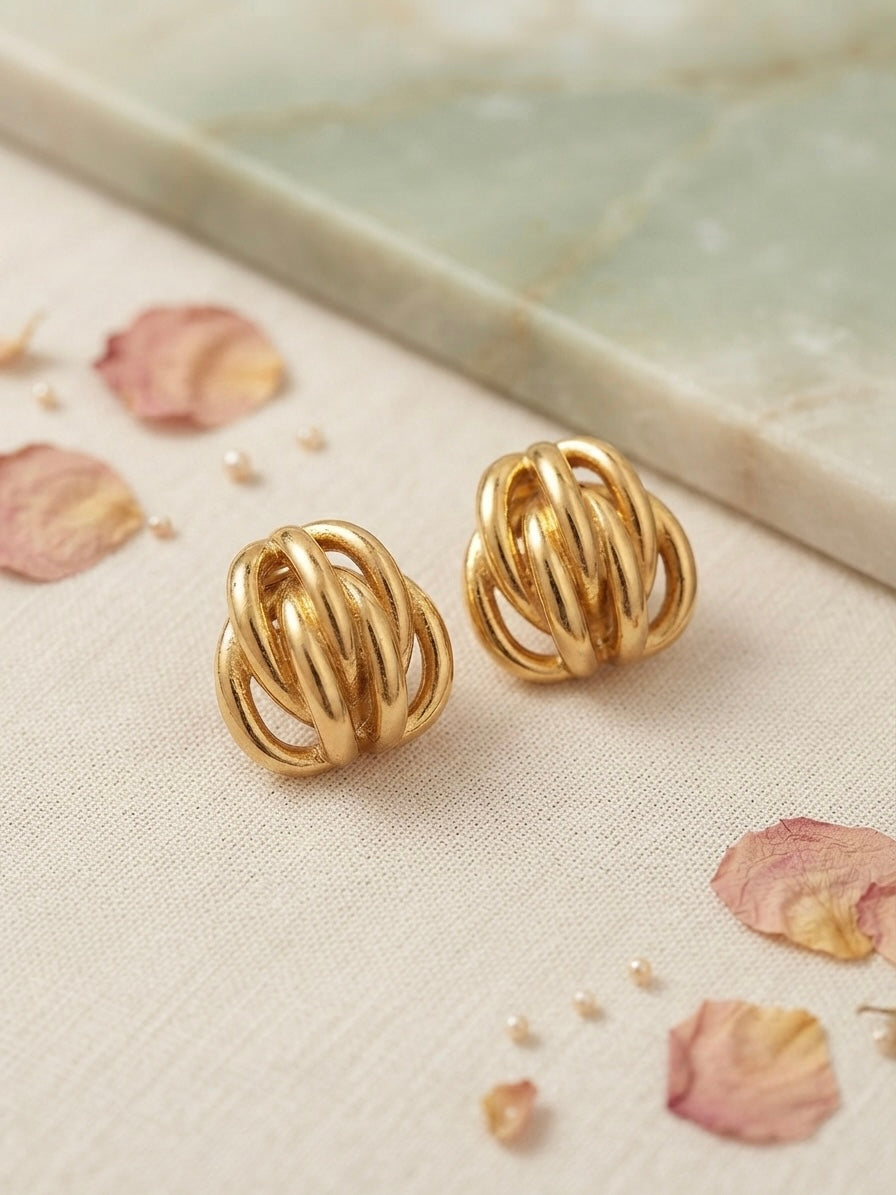 Interwoven golden cage statement earrings.