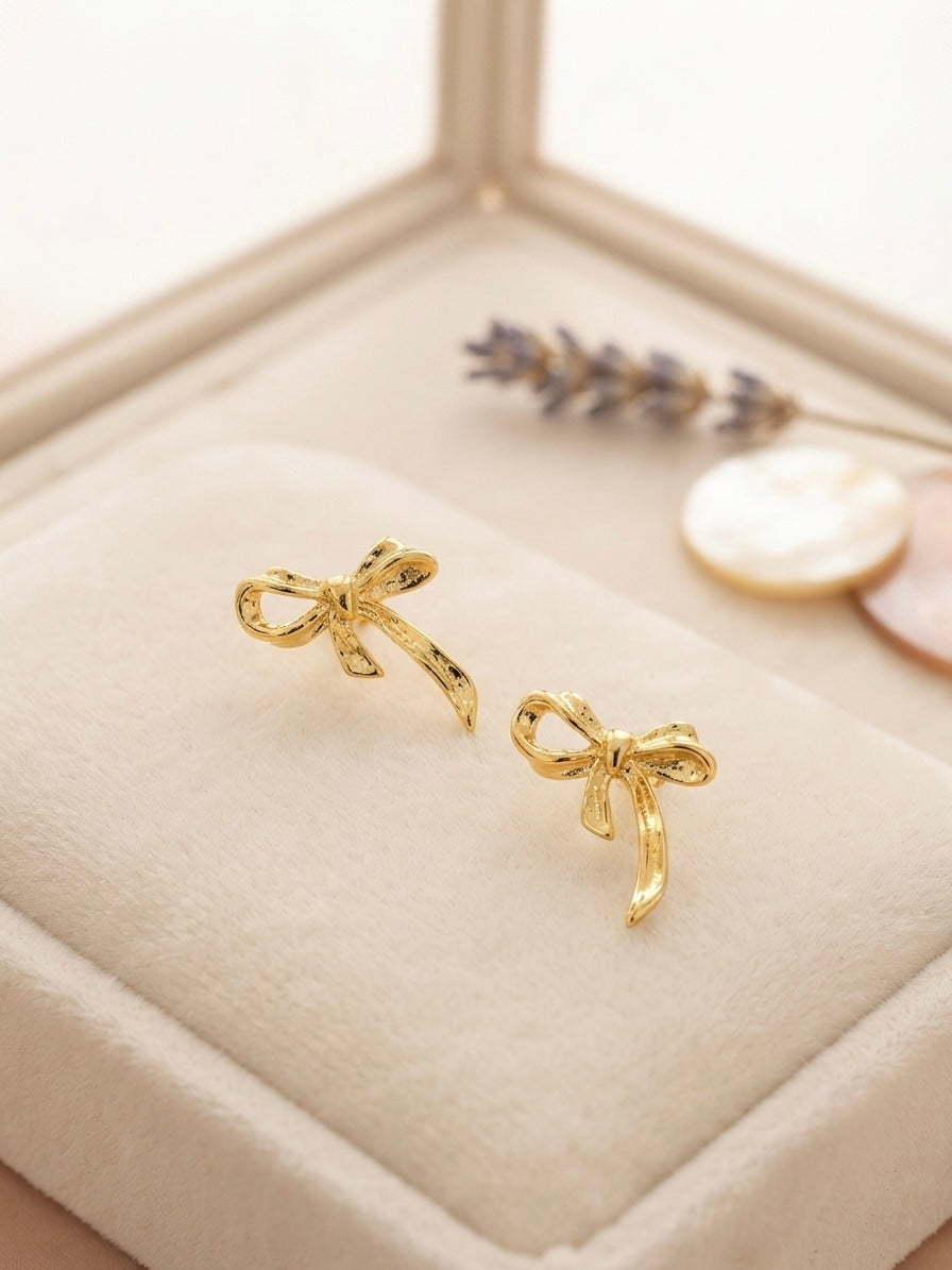 Textured gold ribbon bow earrings.