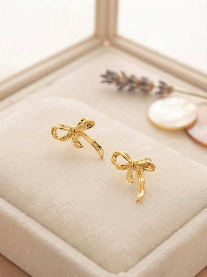 Textured gold ribbon bow earrings.