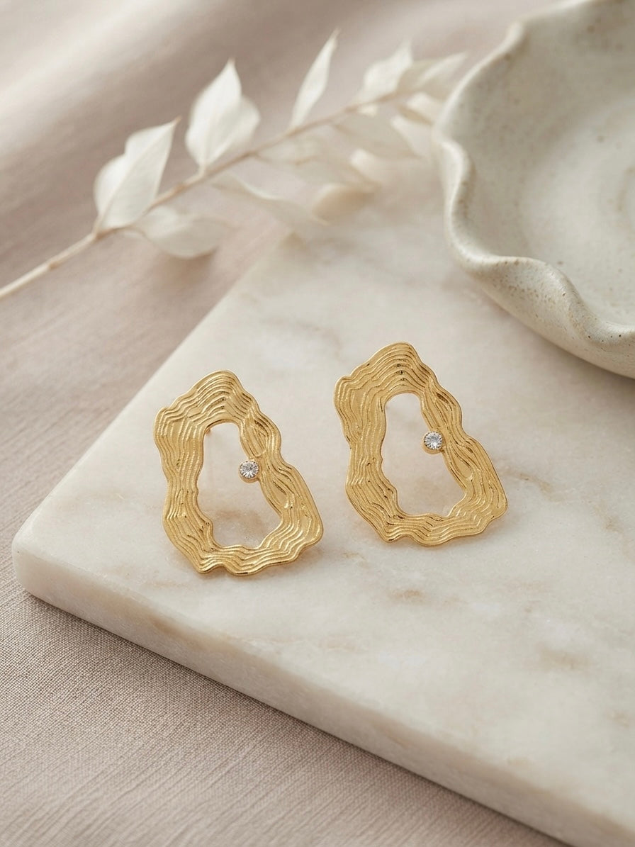 Textured wavy gold crystal hoop earrings.