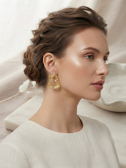 Textured wavy gold crystal hoop earrings.