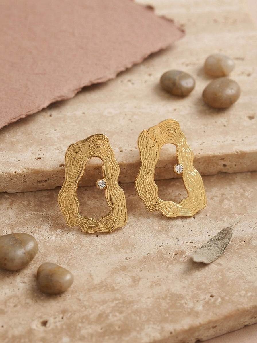 Textured wavy gold crystal hoop earrings.
