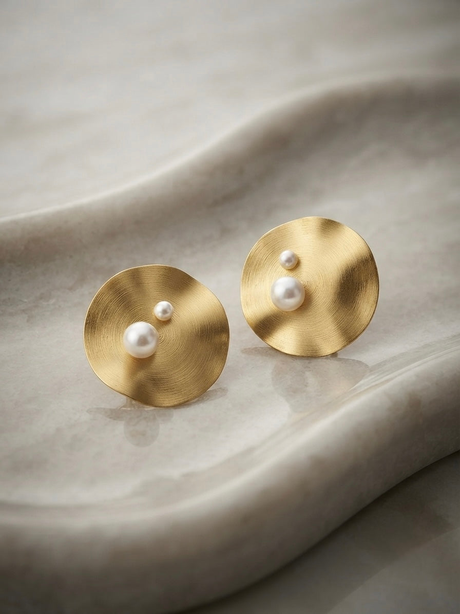 Modern concentric gold disc pearl studs.