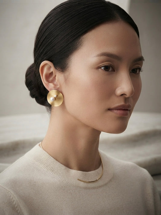 Modern concentric gold disc pearl studs.
