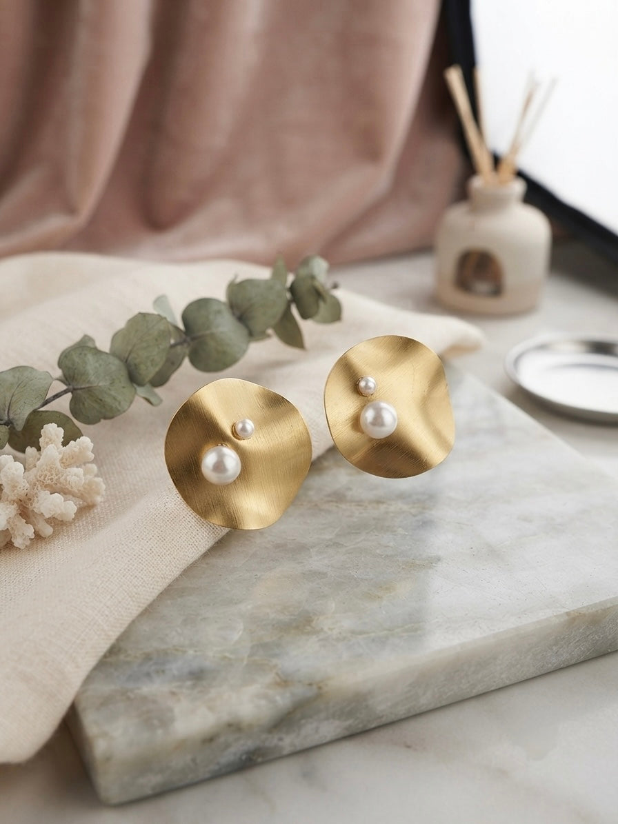 Modern concentric gold disc pearl studs.