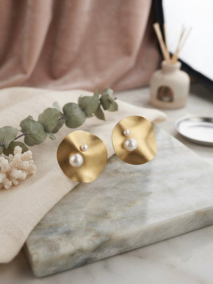 Modern concentric gold disc pearl studs.